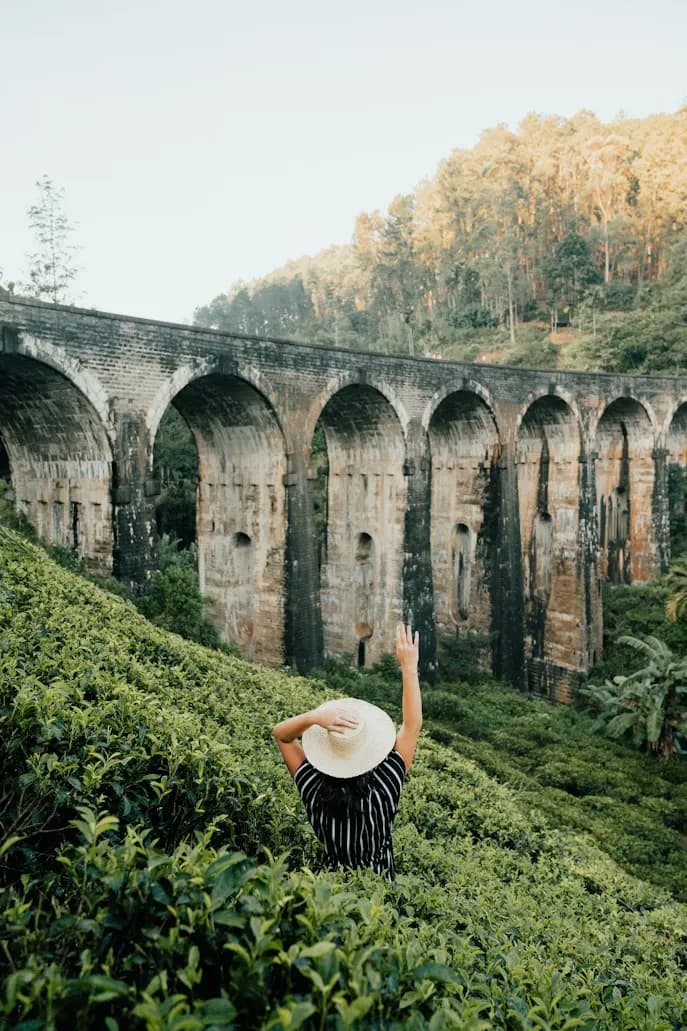 Woman in striped dress admiring nine-arch bridge