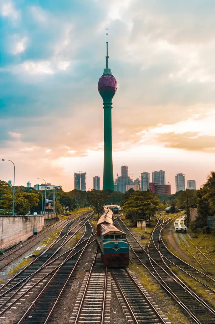 Train on tracks with Colombo Tower and cityscape