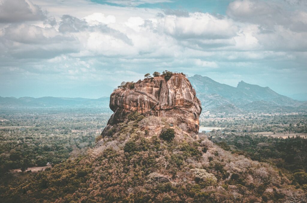 brown rock formation under white clouds during daytime