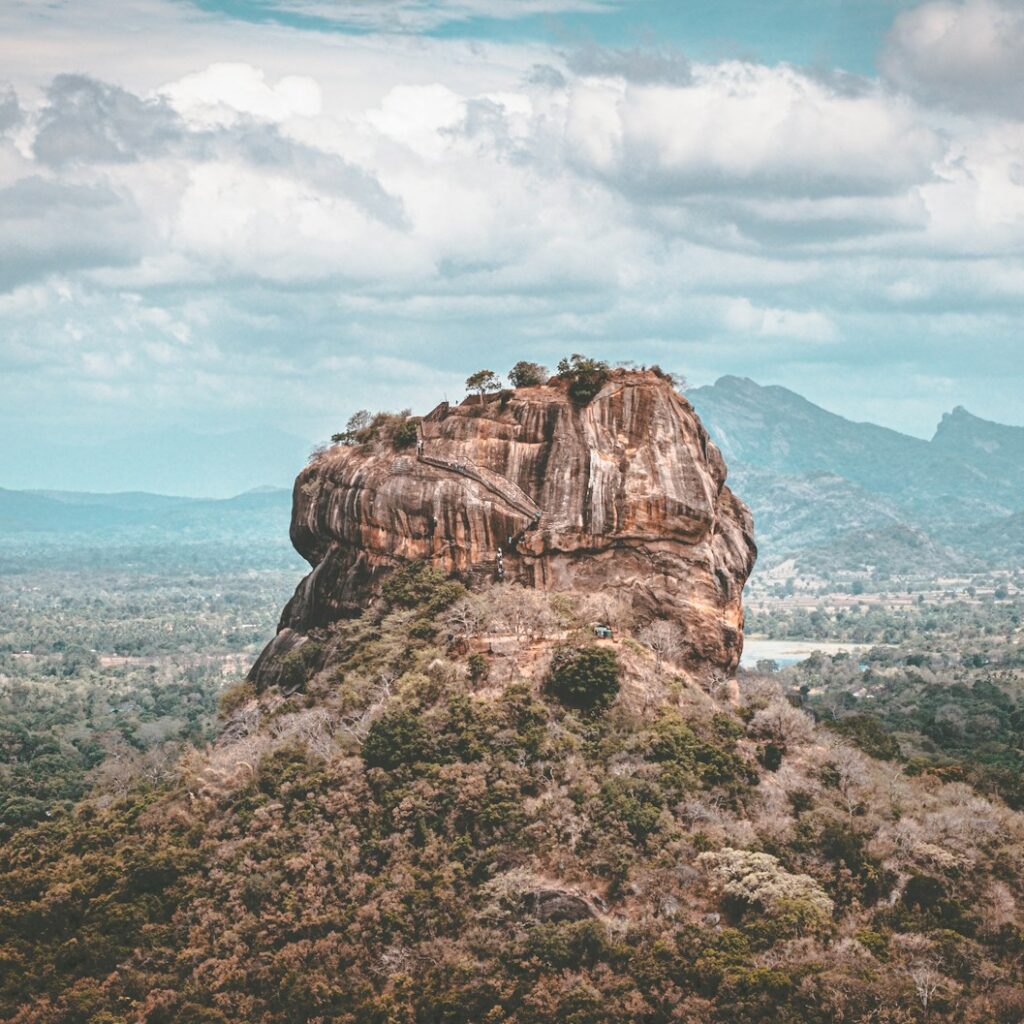 brown rock formation under white clouds during daytime